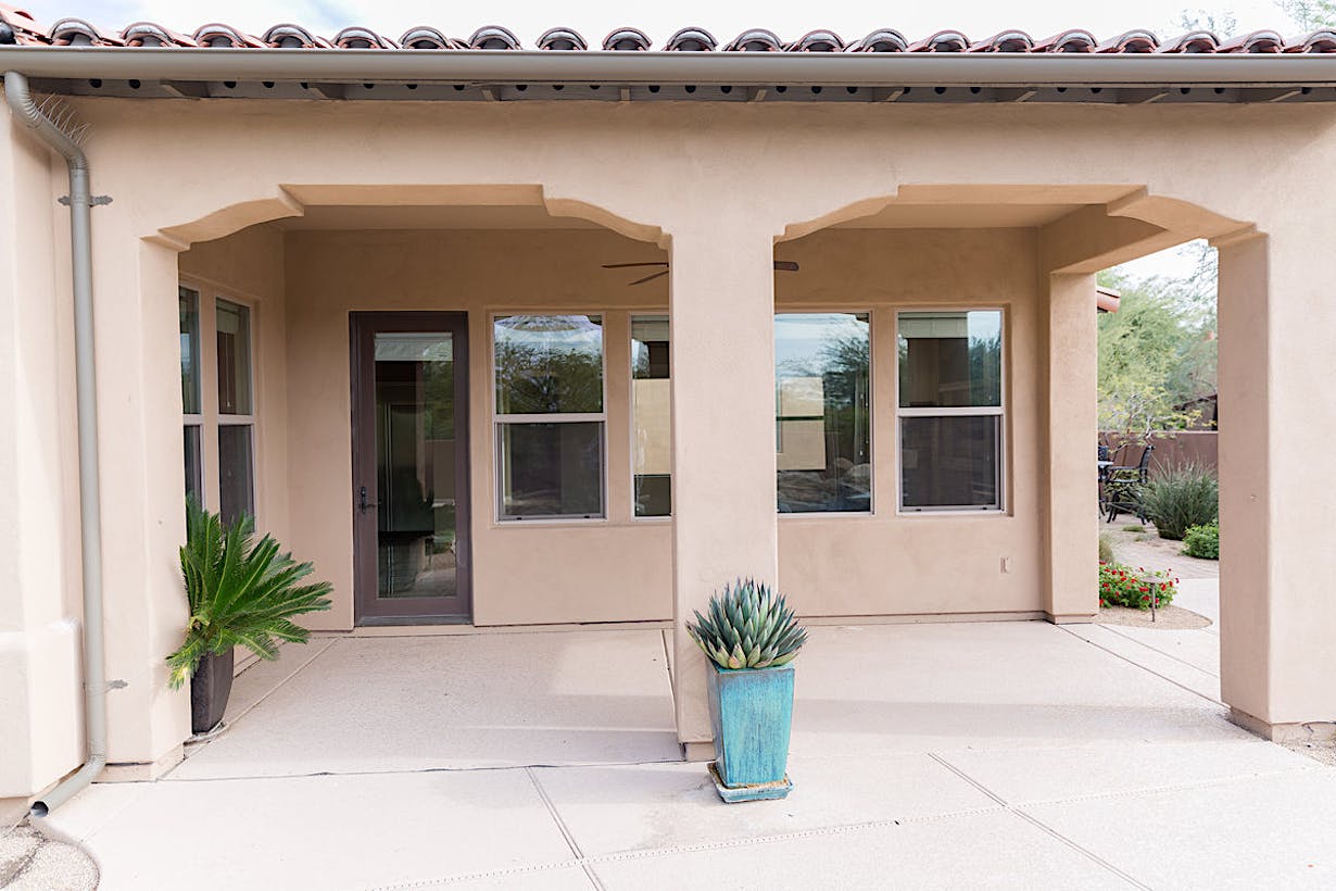 the exterior of the tuscun-style home before remodel
