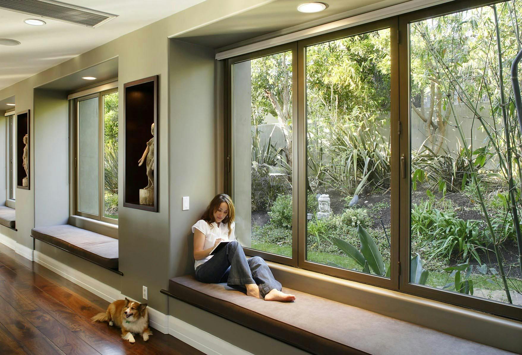 Woman exploring ideas in front of folding glass window