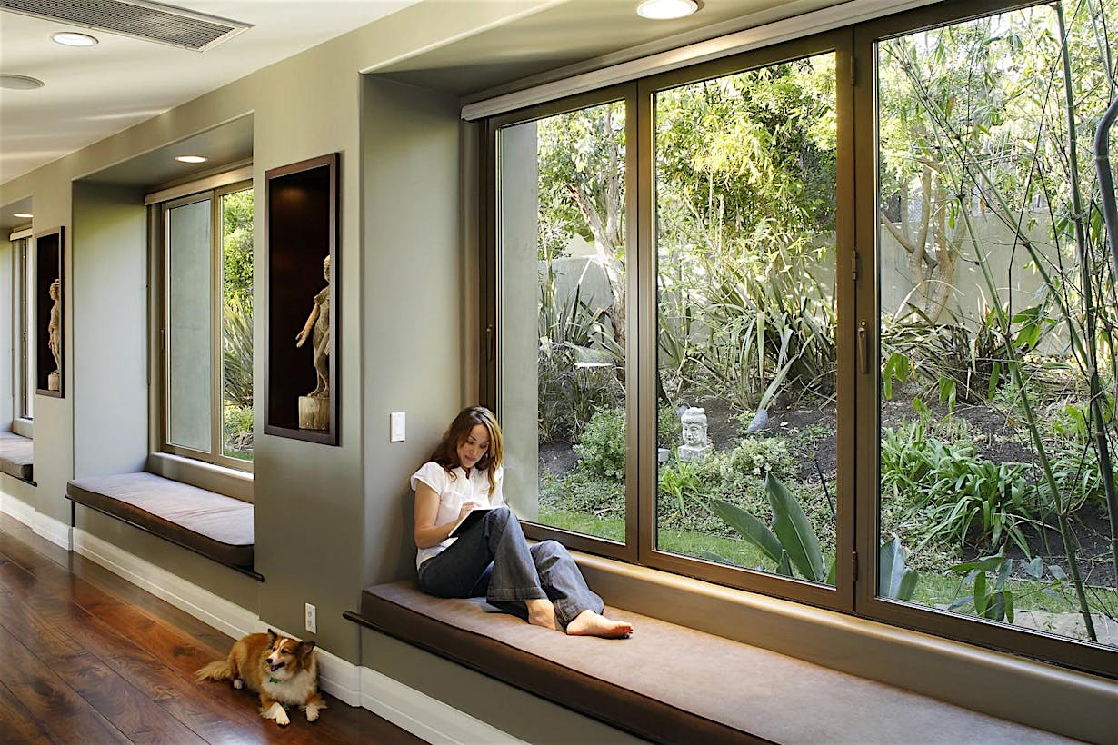 Woman exploring ideas in front of folding glass window