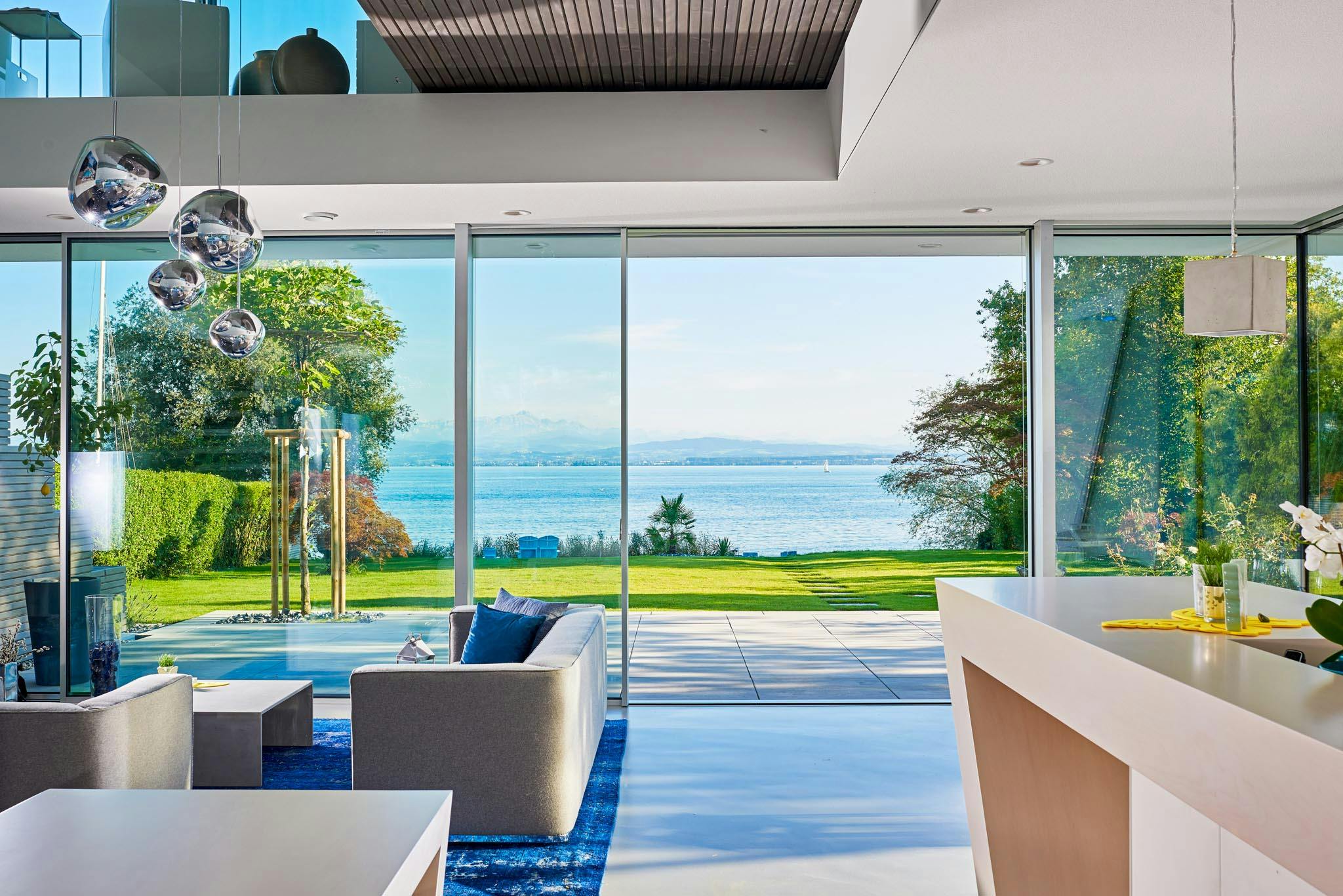 minimal sliding glass walls in serene waterfront home