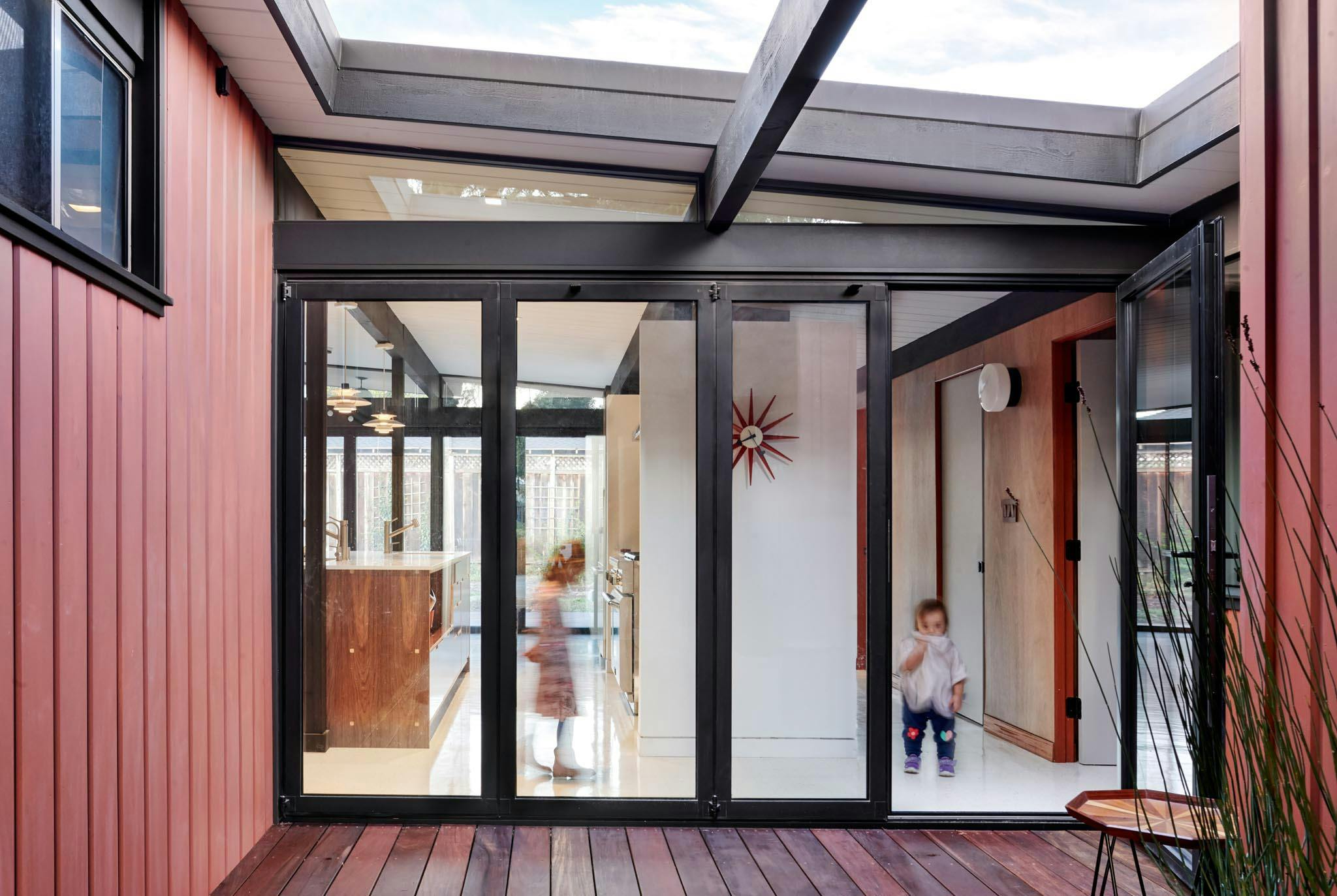 folding glass wall in Eichler remodel to connect home to courtyard