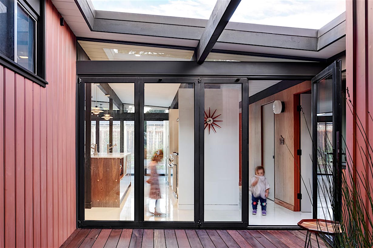 folding glass wall in Eichler remodel to connect home to courtyard
