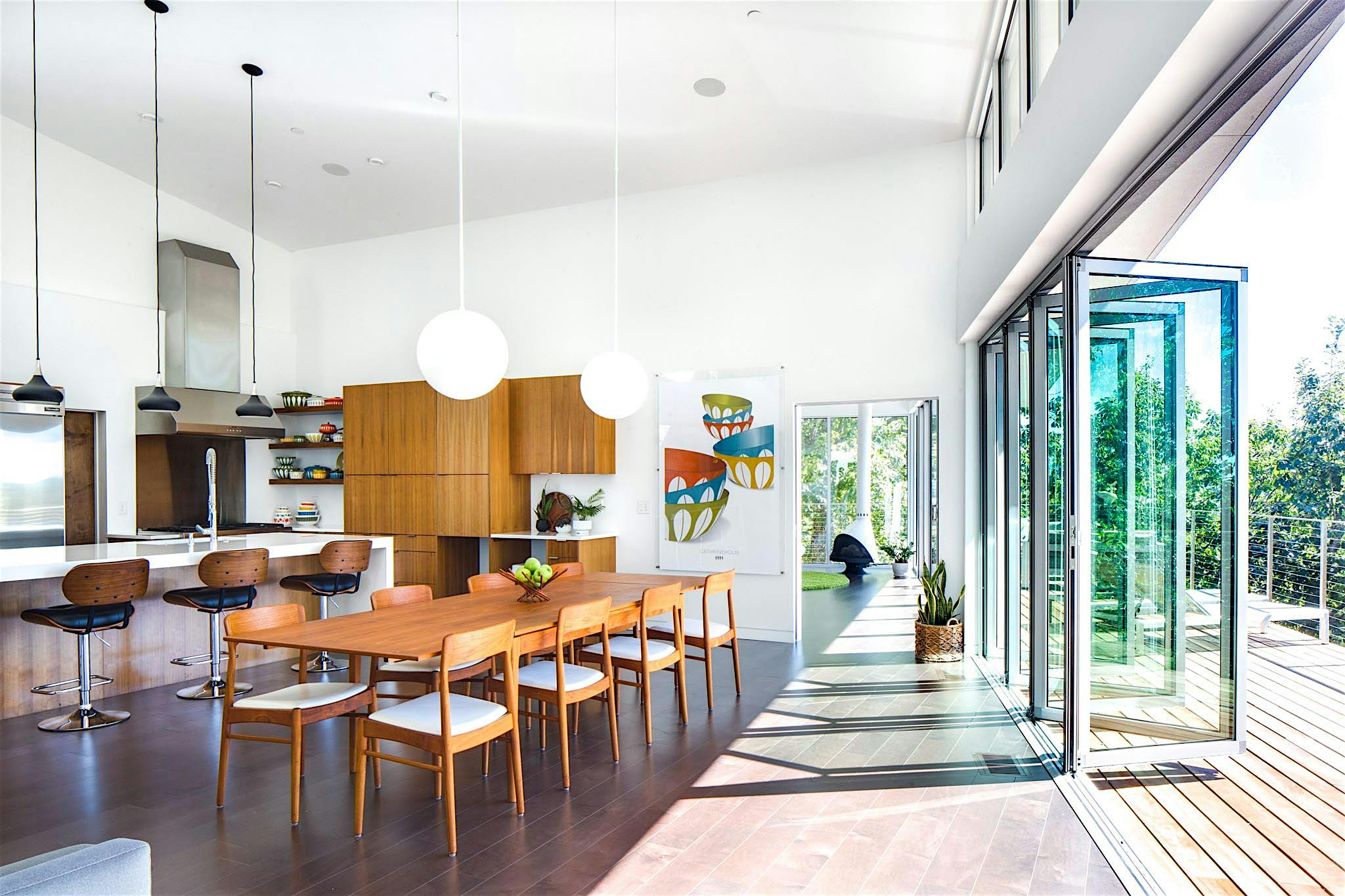 folding glass wall partially open in dining room with hillside view