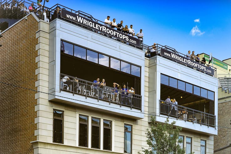 wrigley rooftops with folding glass walls open for viewing live games of baseball with patrons