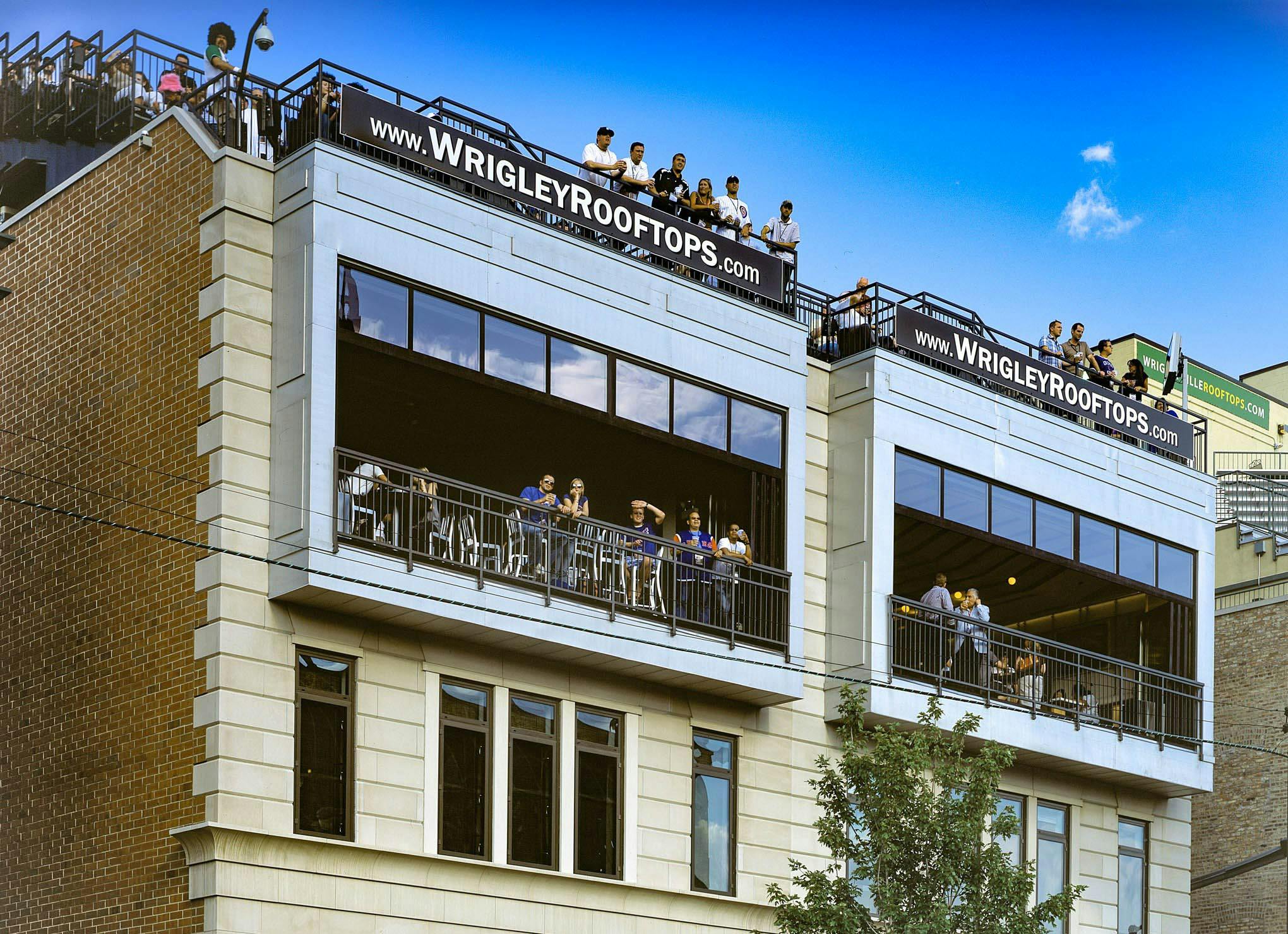 wrigley rooftops with folding glass walls open for viewing live games of baseball with patrons