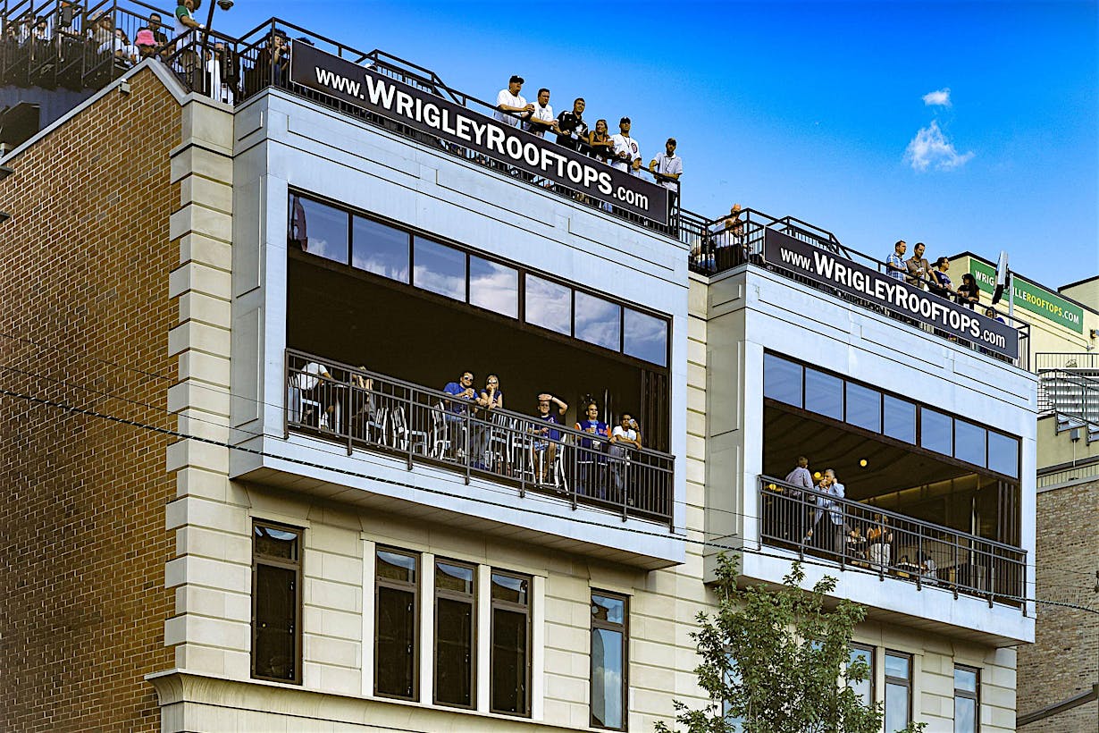 wrigley rooftops with folding glass walls open for viewing live games of baseball with patrons