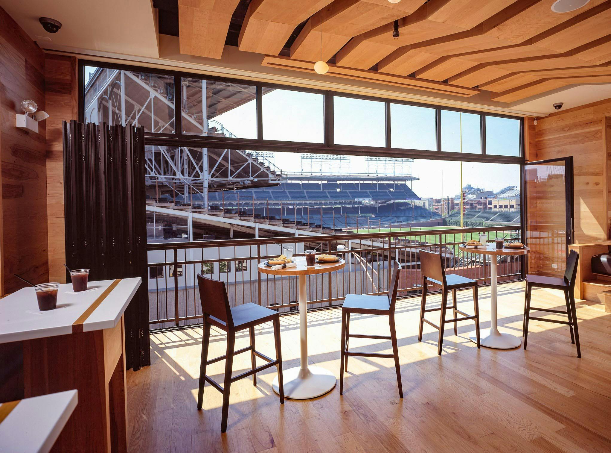 wrigley rooftops hospitality venue with folding glass wall open for view of baseball field
