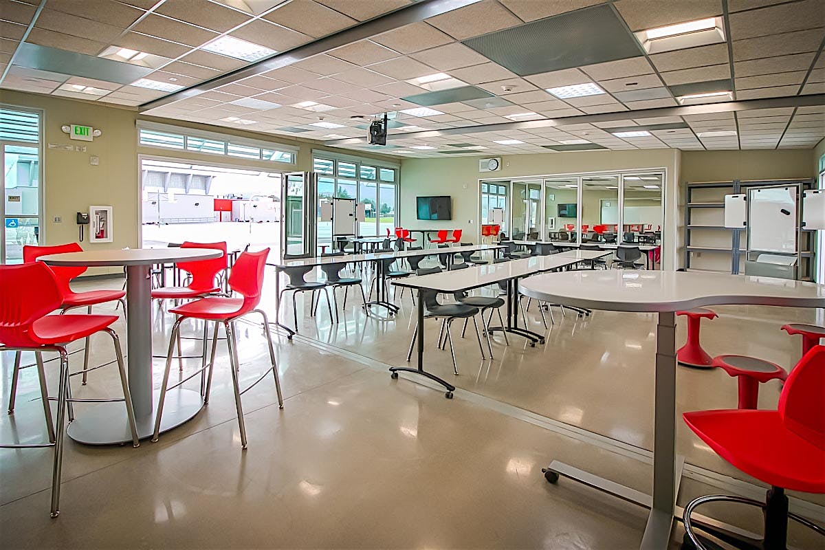 multiple classroom enlarged into one with folding glass walls interior and exterior