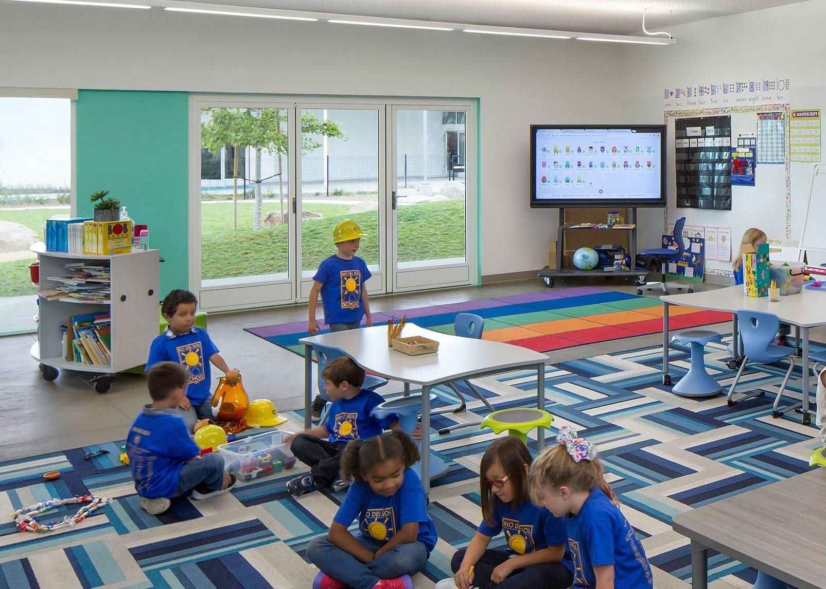 learning hub in 21st Century Classroon Design with opening glass walls and children collaborating