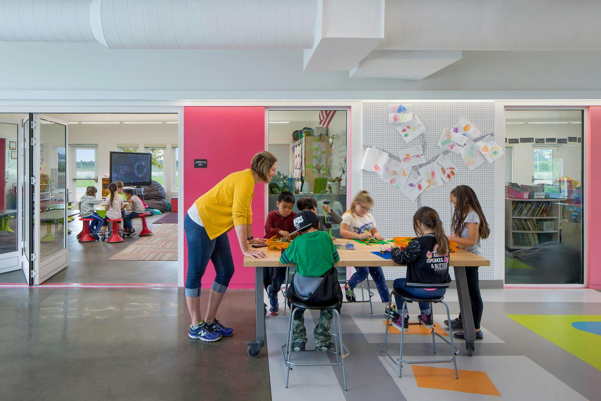 collaborative learning in schools with learning hub and flexible folding glass walls with teacher and kids