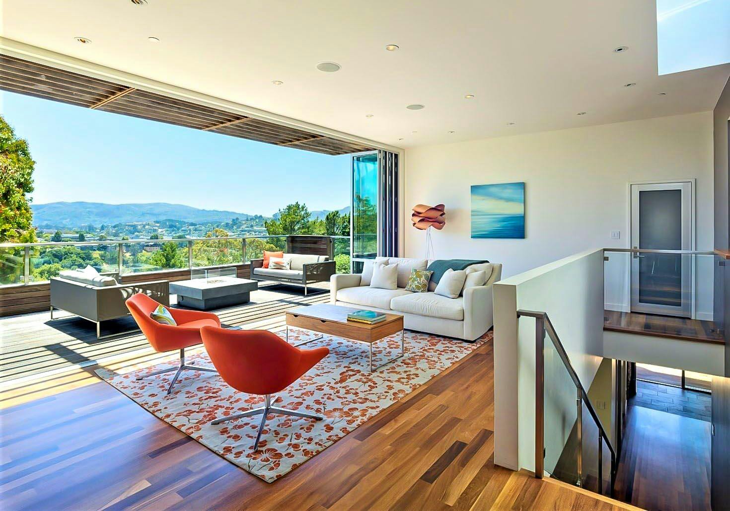 indoor/outdoor living achieved in hillside home with folding glass wall in living room remodel