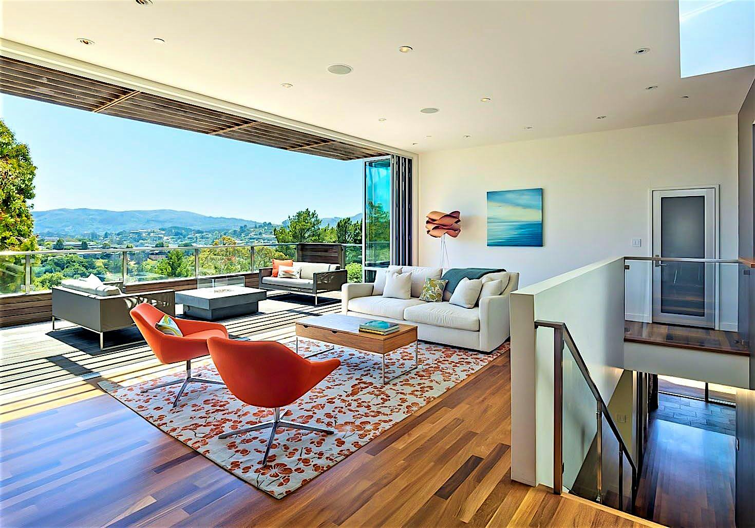 indoor/outdoor living achieved in hillside home with folding glass wall in living room remodel