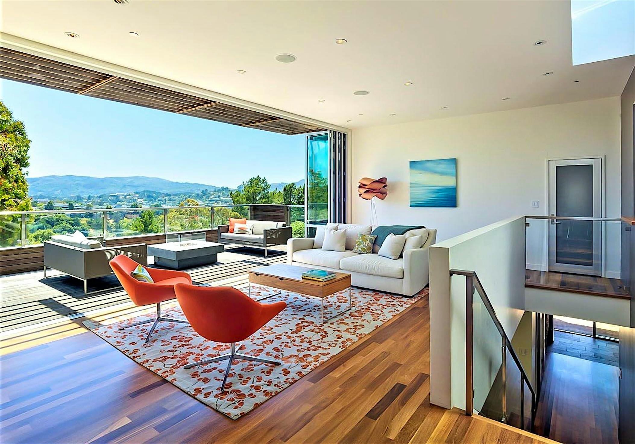 indoor/outdoor living achieved in hillside home with folding glass wall in living room remodel