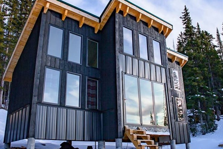 tiny living home with folding glass walls in the snow