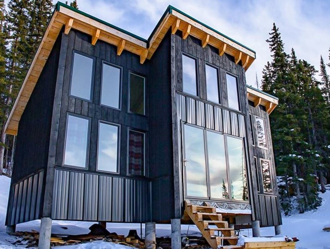 tiny living home with folding glass walls in the snow