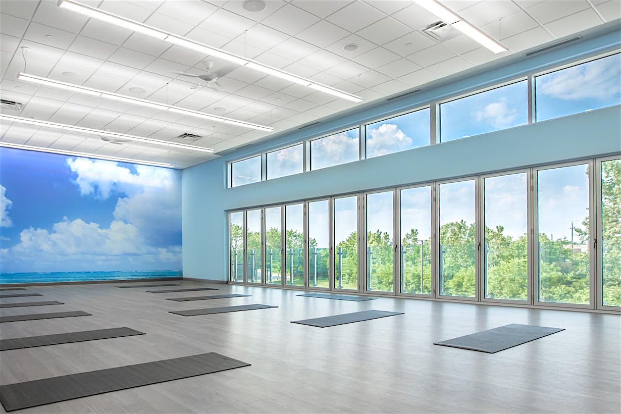 Movati athetlectic facility yoga room with closed folding glass wall