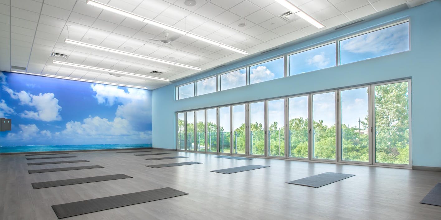 Movati athetlectic facility yoga room with closed folding glass wall