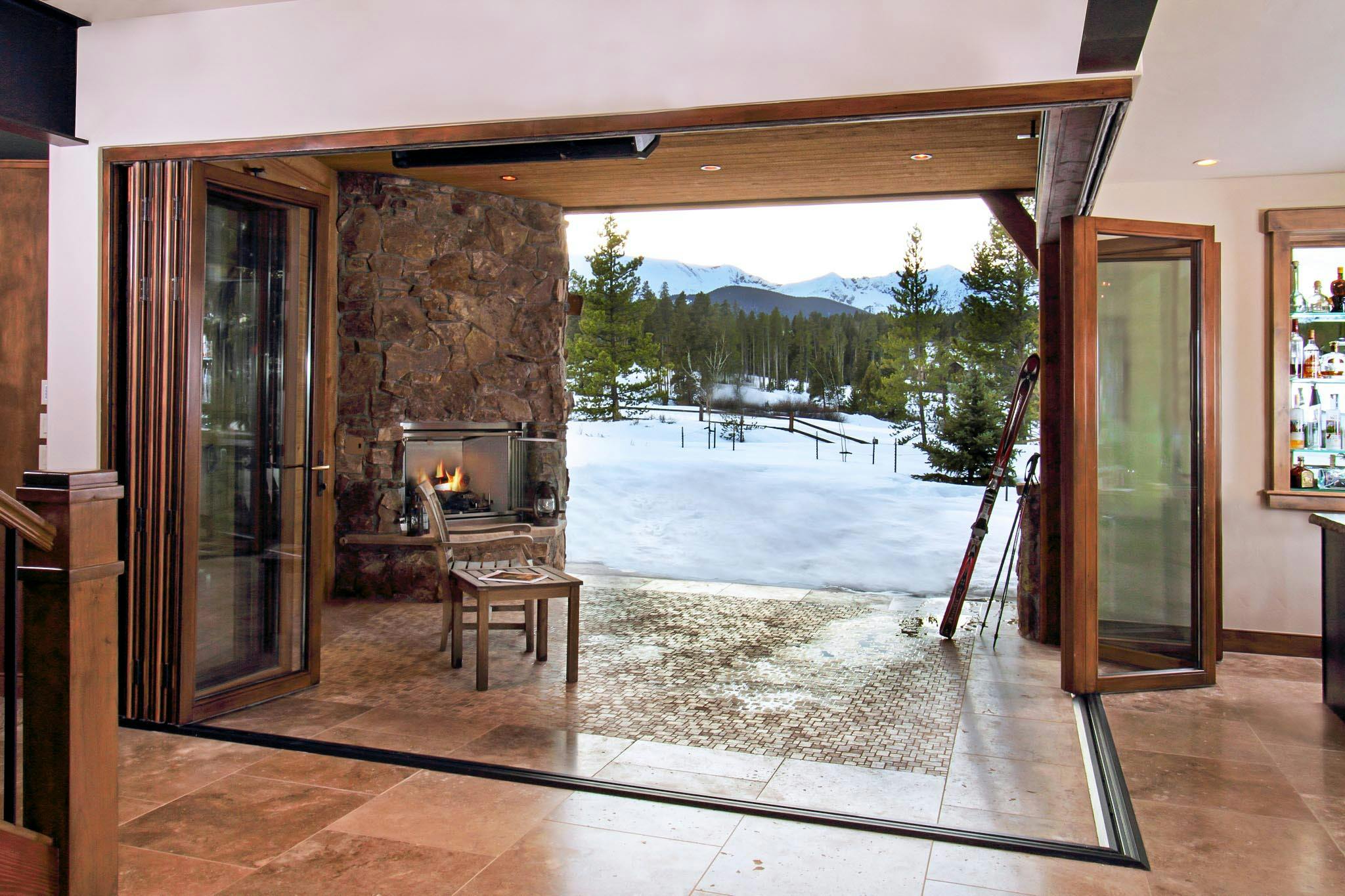 wood framed folding glass wall with open corner design in snow
