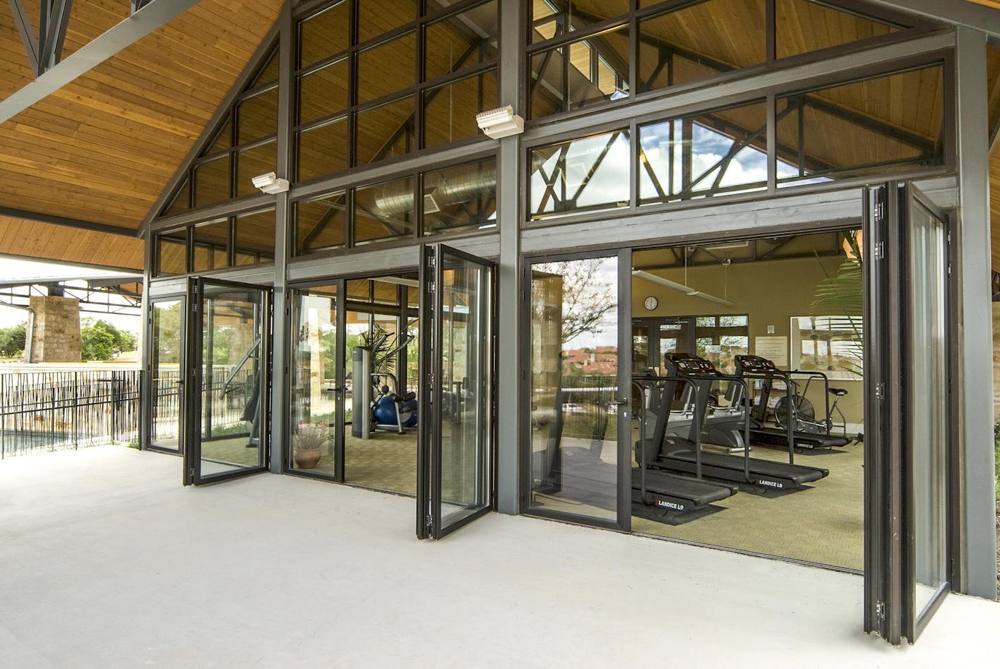 exercise room in multifamily complex with opening glass walls