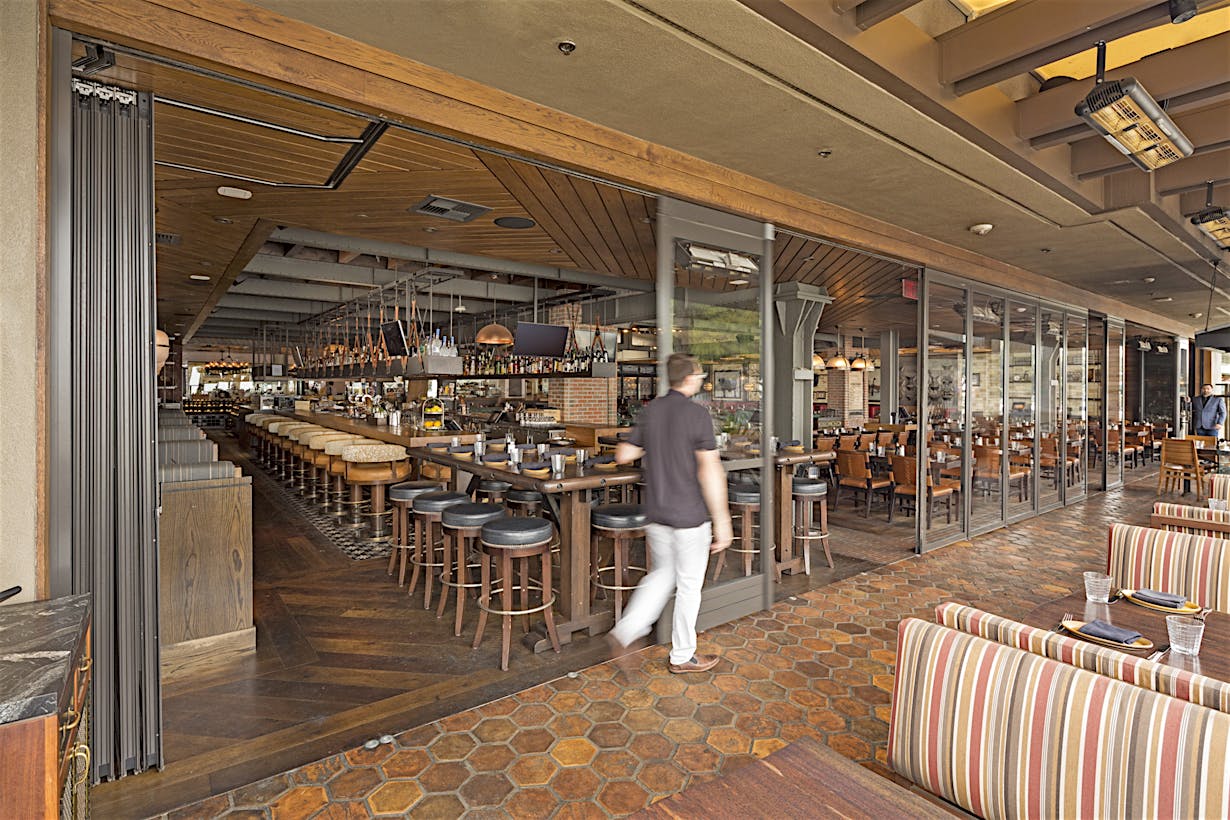 opening the commercial stacking glass doors at a restaurant