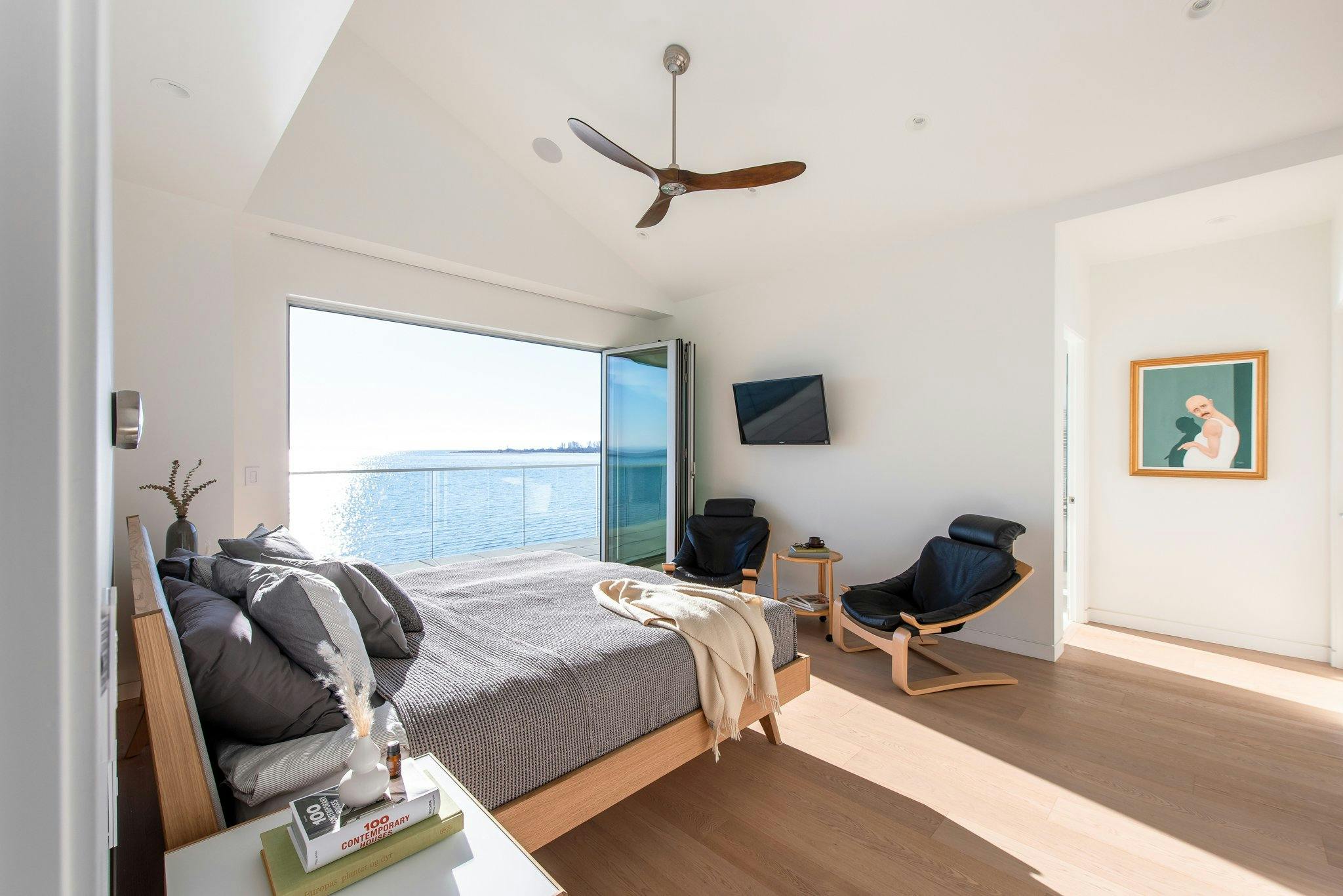 exterior glass wall systems in bedroom with ocean view