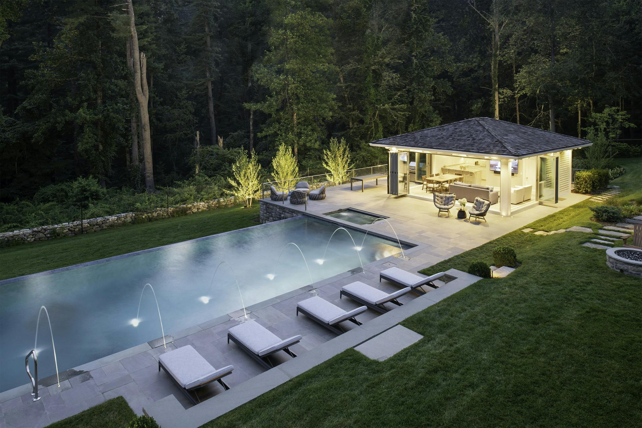 pool house glows with open folding glass walls by NanaWall