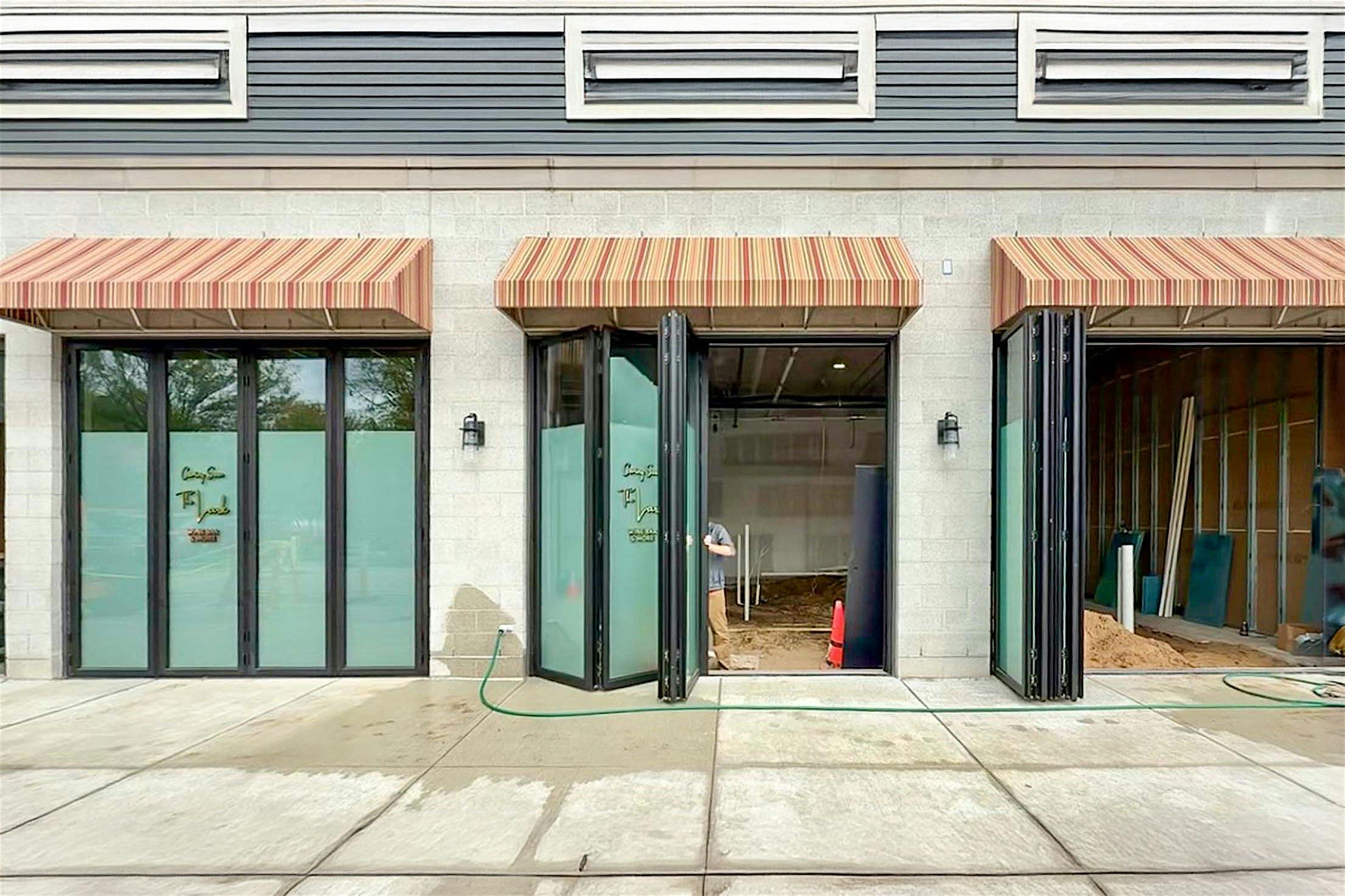 A building exterior features bifold glass doors, enhancing the hospitality design.