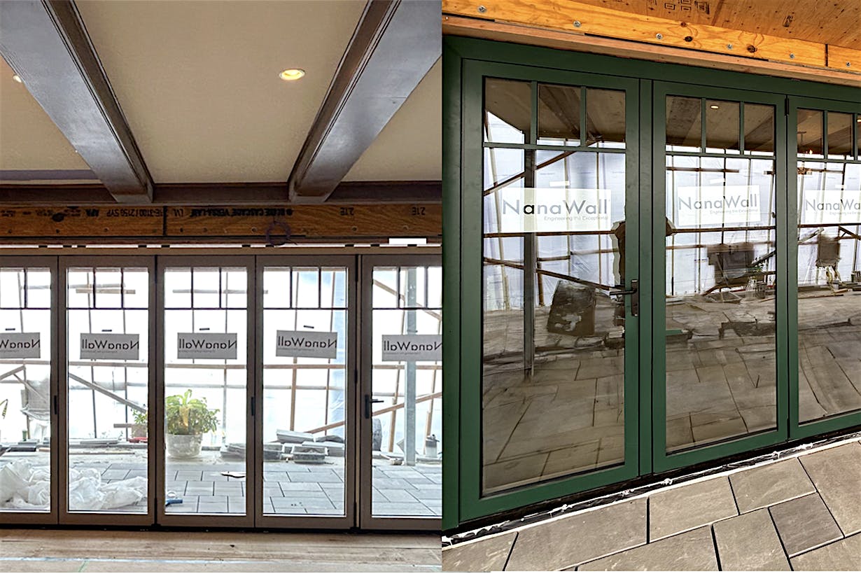 Large set of floor-to-ceiling folding glass doors finished in a dark green powder-coated exterior and rich wood interior.