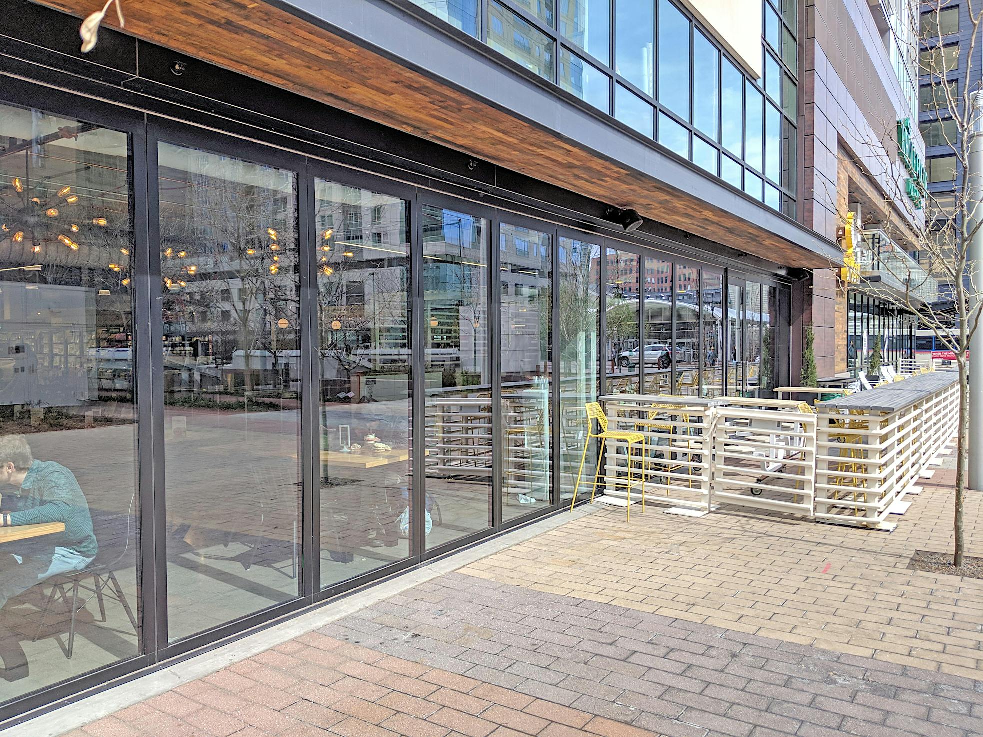 Whole Foods lower level moving glass wall systems separates eating area from sidewalk