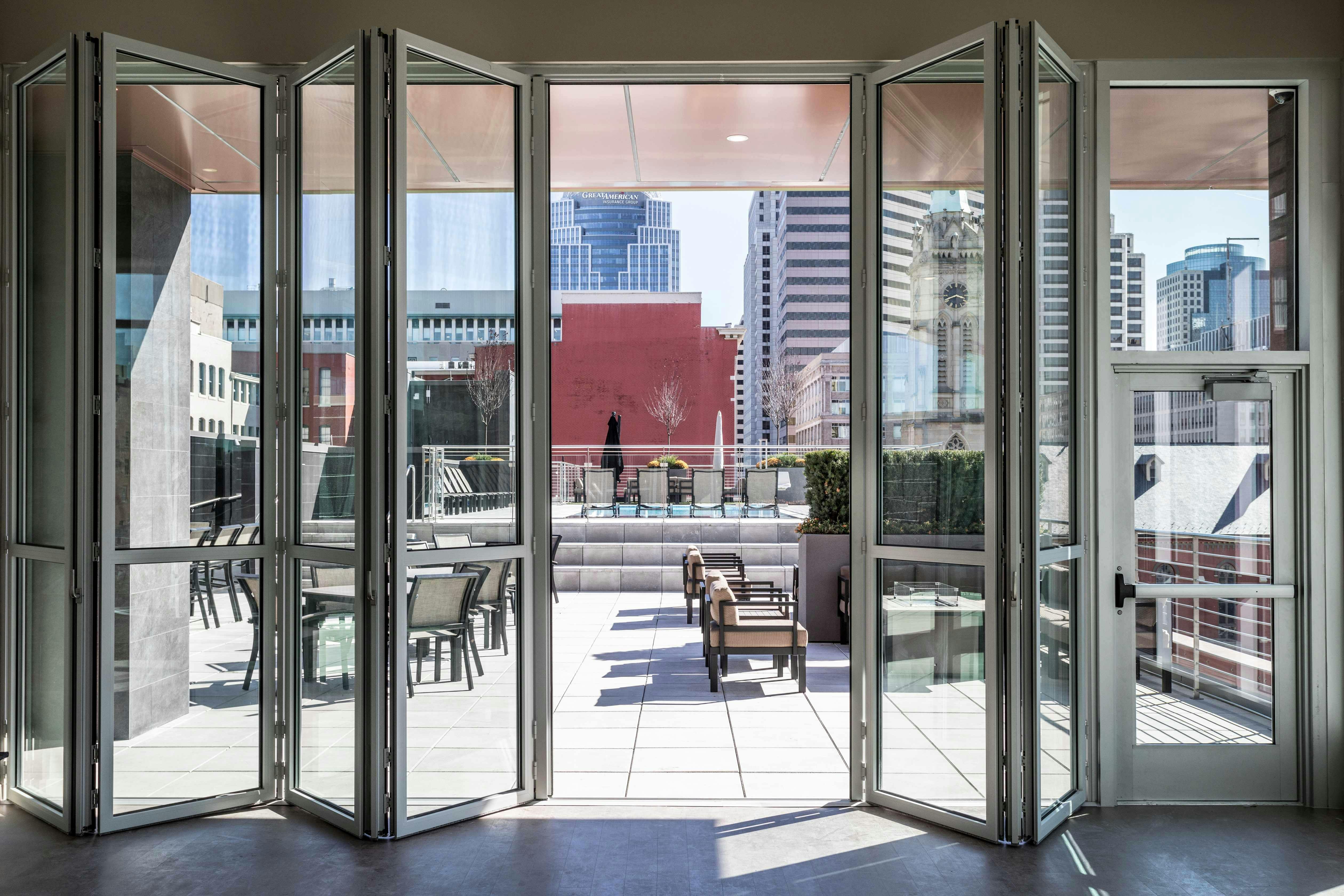 tall-folding-glass-walls-opening-to-multifamily-rooftop
