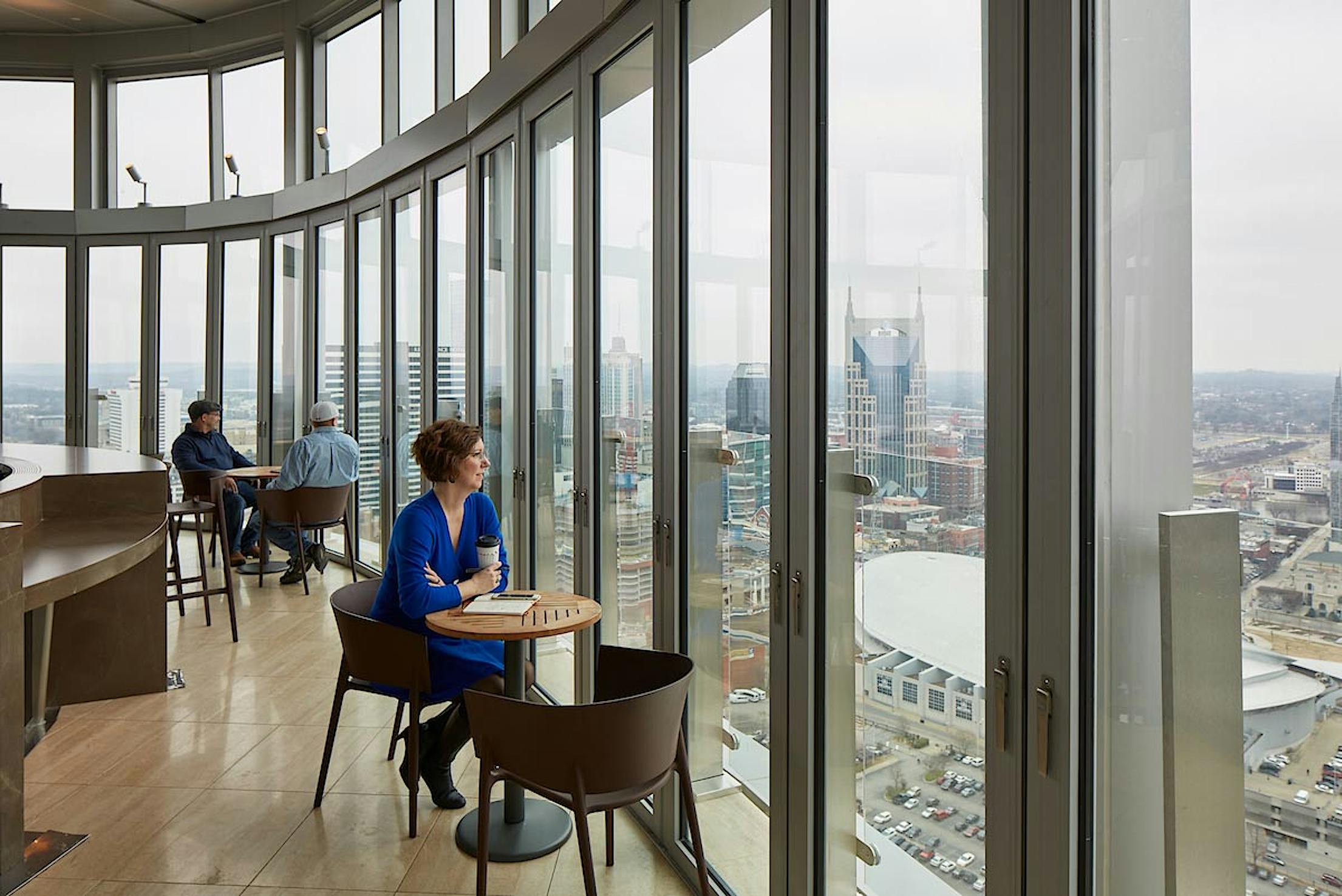 patron-sitting-next-to-opening-glass-wall-at-bourbon-skybar-and-restaurant