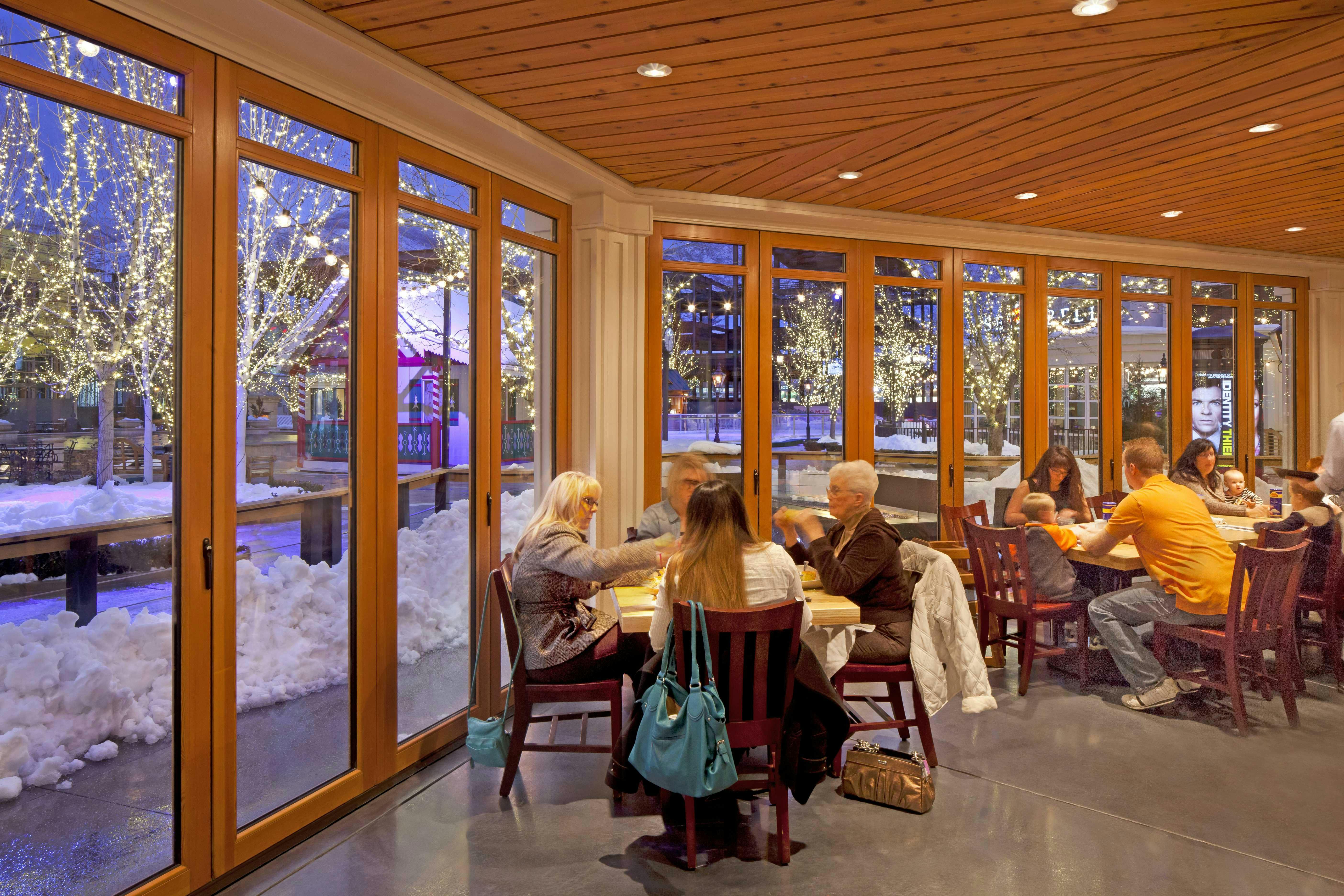 people-eating-in-restaurant-next-to-glass-with-snow-outside