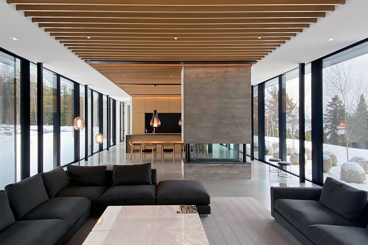 A living room with a large extreme weather conditions glass wall on both side of the room