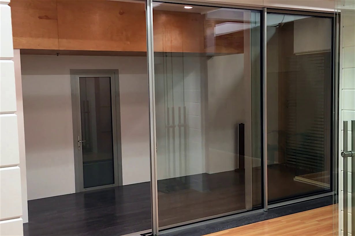 Modern interior with sliding glass doors, dark flooring, and a closed door, offering seamless style and automation potential.