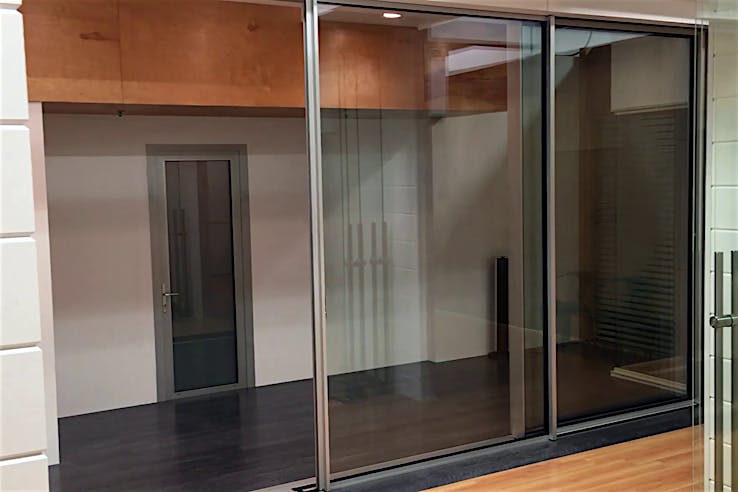 Modern interior with sliding glass doors, dark flooring, and a closed door, offering seamless style and automation potential.