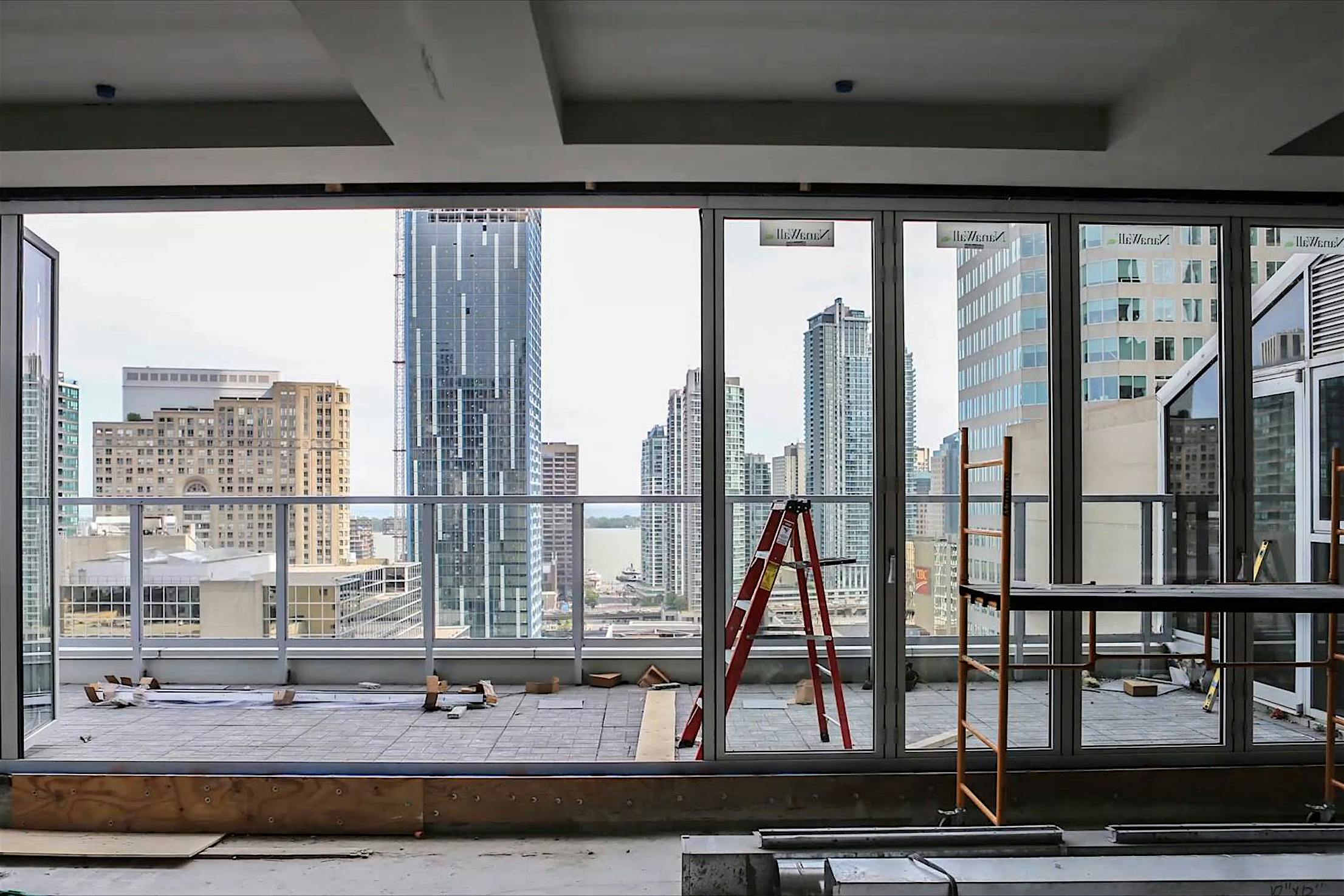 Interior of high-rise under construction with large glass windows and doors installed by NanaWall certified installation network.