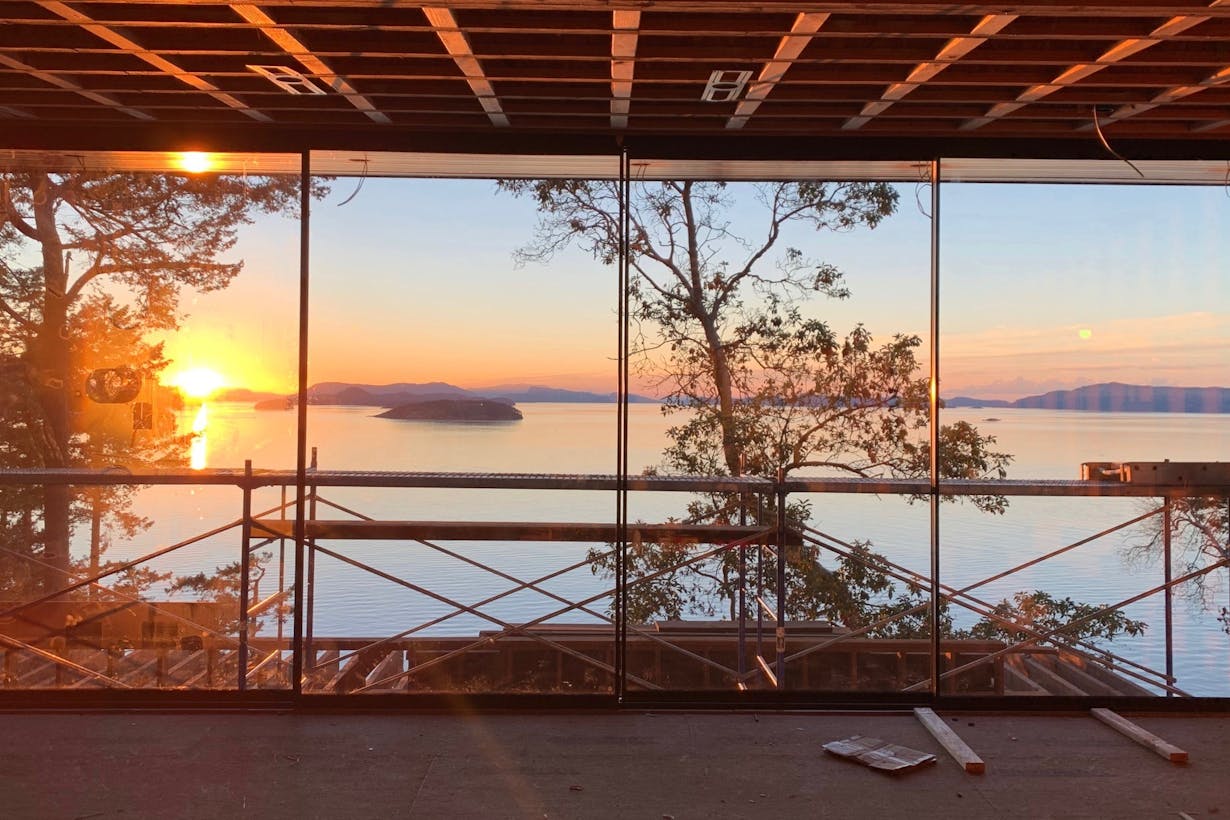 A view of the sunset through minimal floor-to-ceiling glass walls