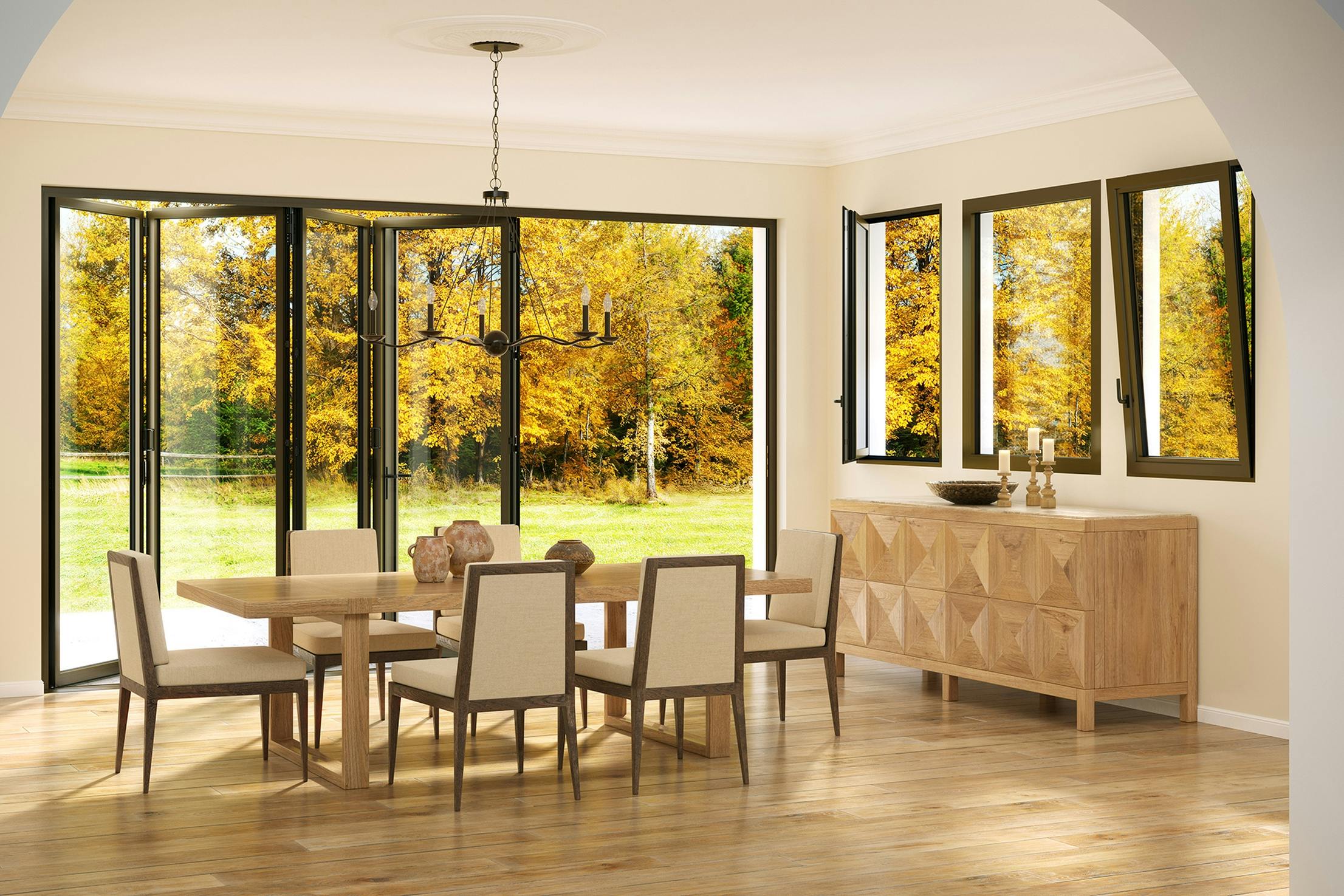 A dining room with tilt turn windows showing autumn trees, and a sideboard with candles and decorative items.