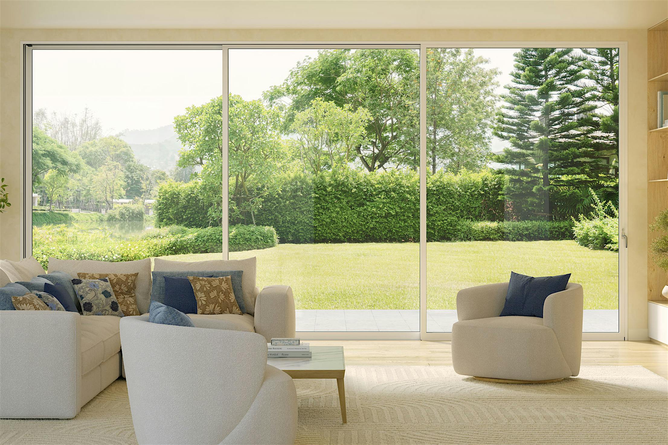 A modern living room with white sofas and a wooden coffee table, featuring slim aluminum framed multislide glass doors overlooking a green garden with trees and shrubs.