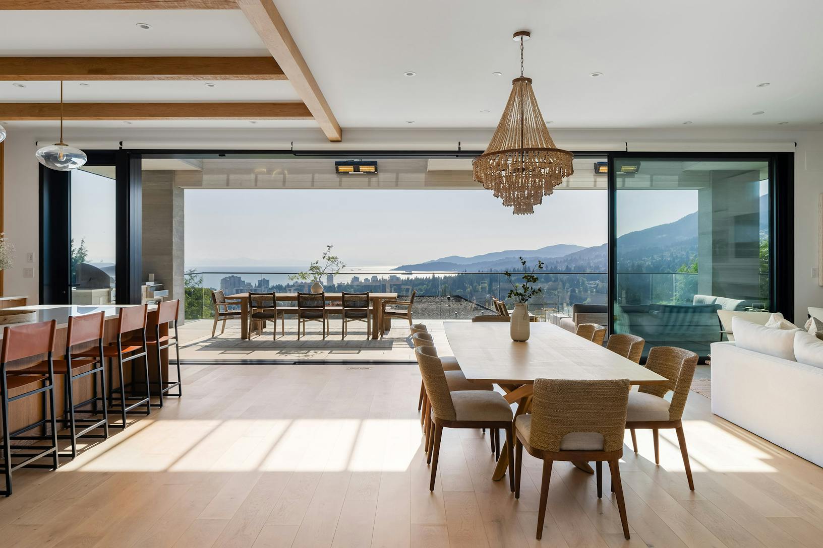 A living room with glass walls that offer a stunning view of the mountains