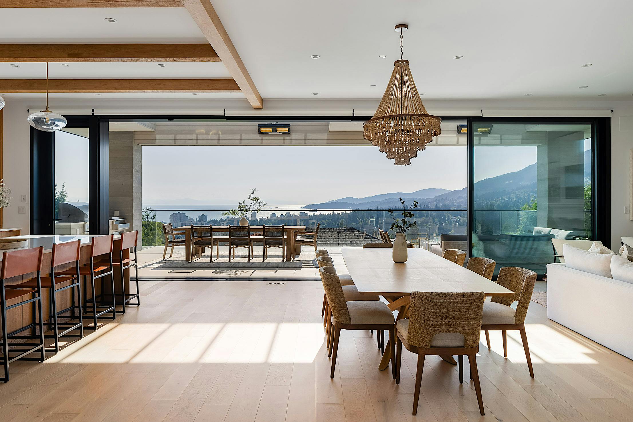 Sliding glass doors in West Vancouver kitchen open to scenic balcony, merging indoor and outdoor living spaces seamlessly.