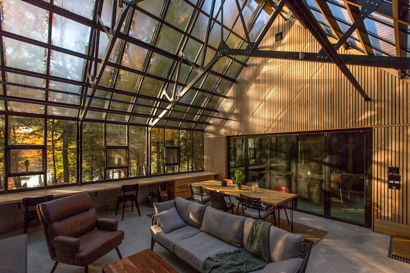 A greenhouse cottage with glass walls that offer a stunning view of the outdoors