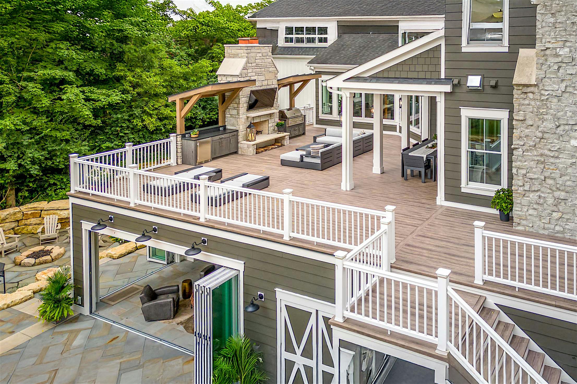 Accordion glass doors open to a spacious rooftop deck with outdoor fireplace, lounge seating, and seamless indoor-outdoor flow
