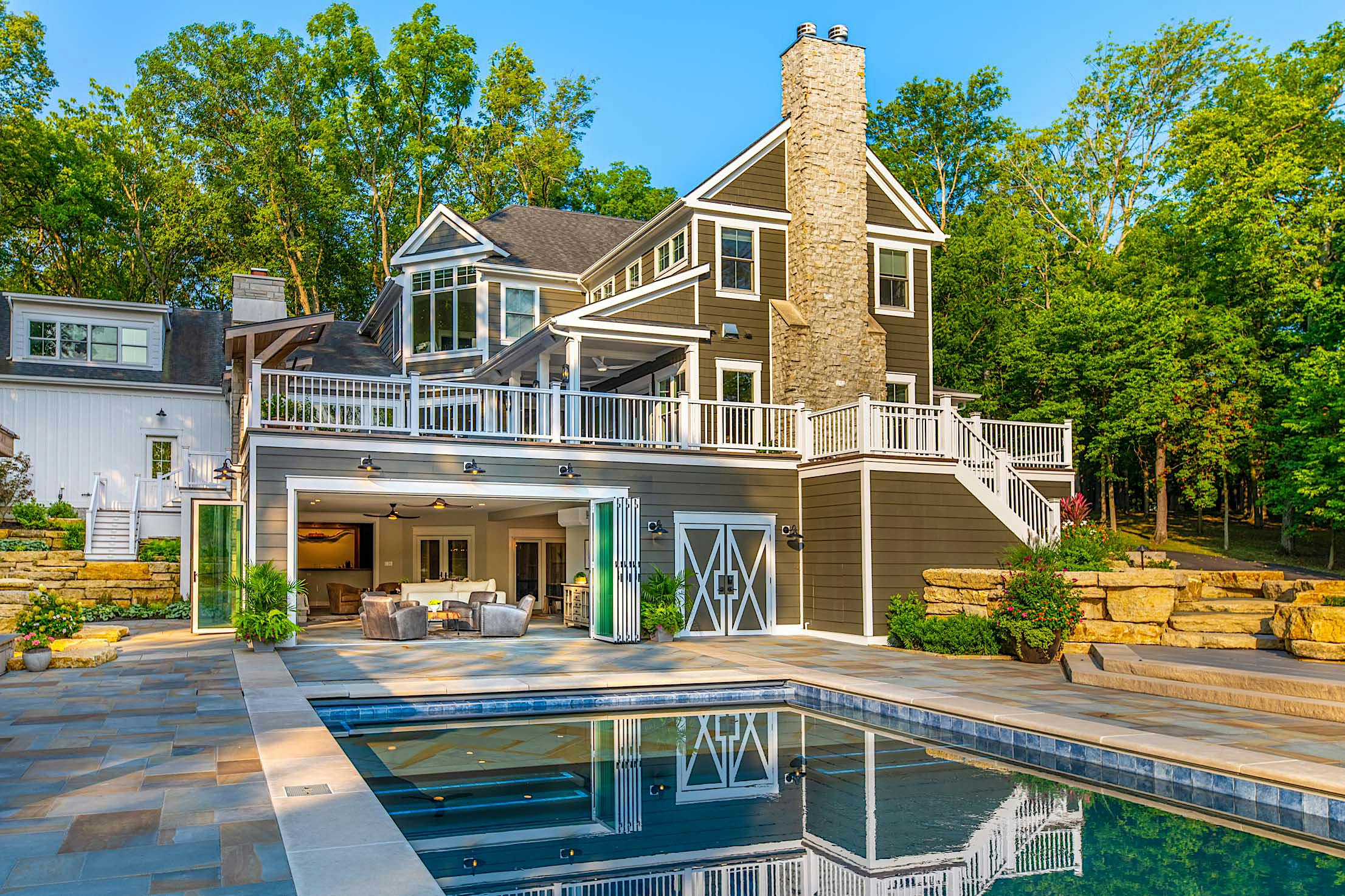 Modern pool house in Columbus, OH with accordion glass doors, blending indoor comfort with outdoor relaxation