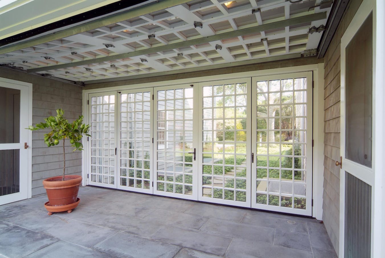 A patio with glass doors and a potted plant