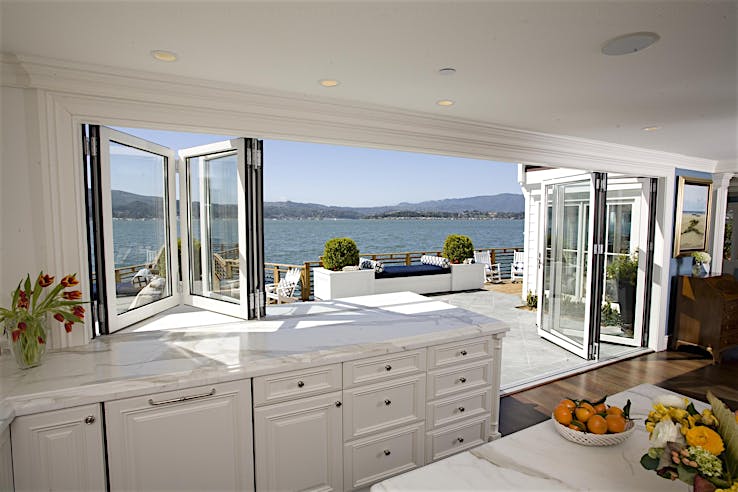 Folding window and door combination in Belvedere, CA kitchen creates seamless indoor-outdoor flow for cooking and dining
