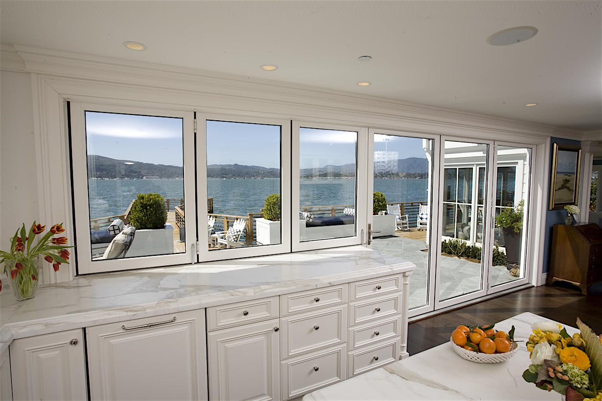 A kitchen with folding triple glazing doors and a view of the ocean