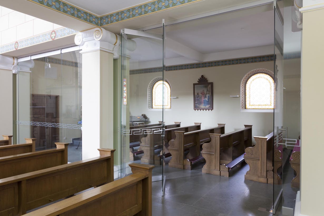 Wooden pews in a church with all glass partitions
