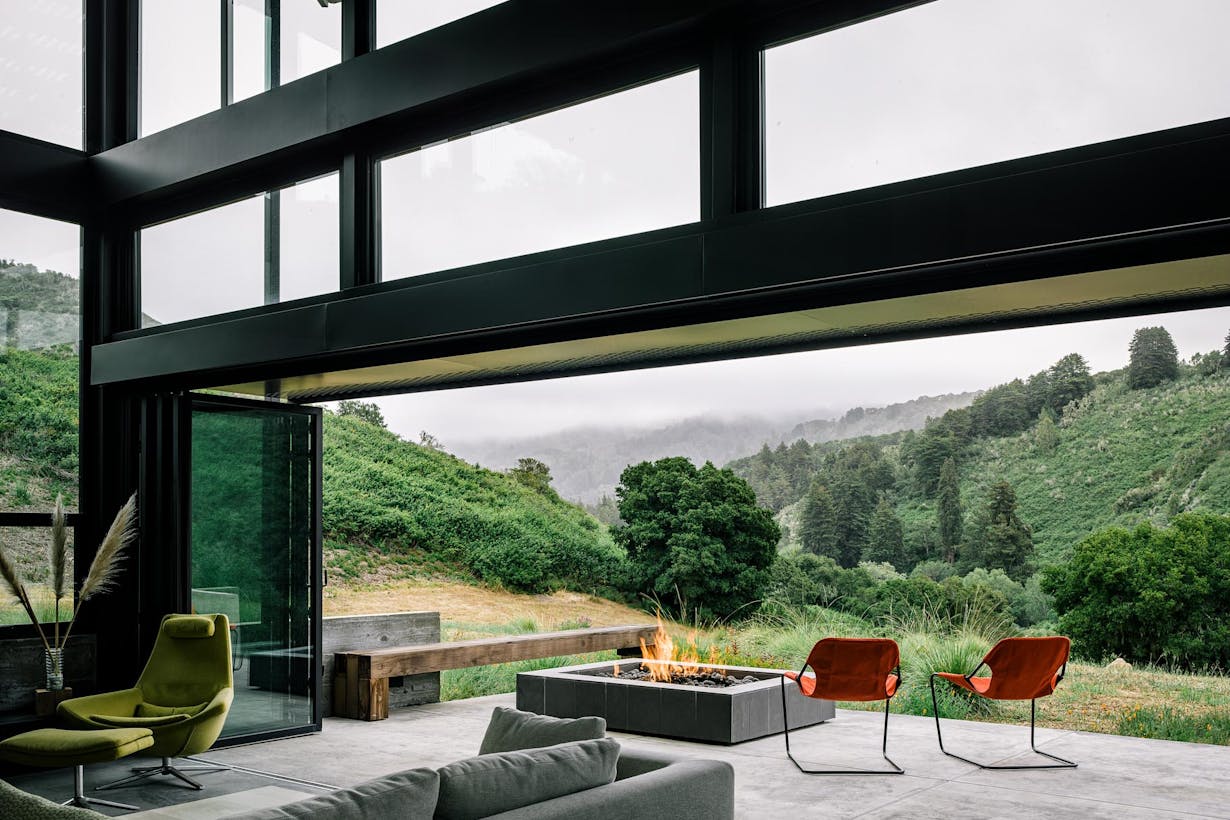 Folding patio doors with chairs and a fire pit with mountains in the background