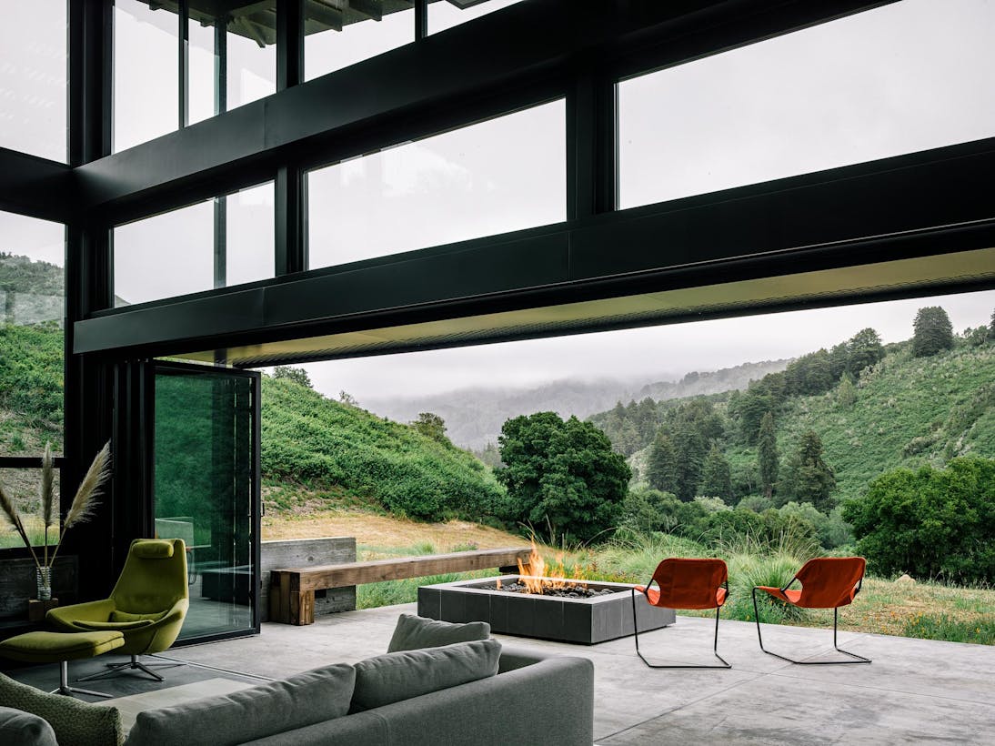 Folding patio doors with chairs and a fire pit with mountains in the background